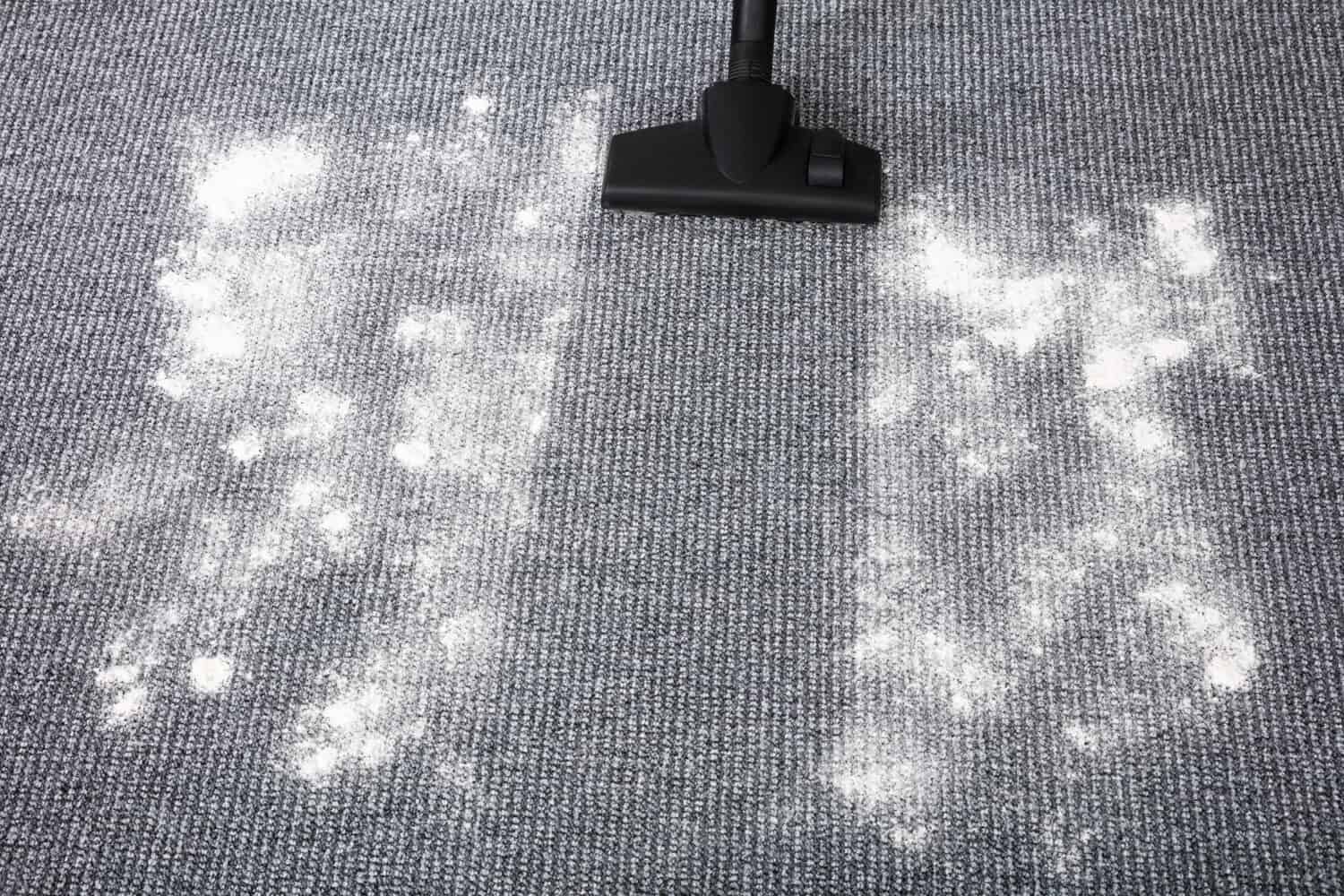 Close-up Of Vacuum Cleaner Cleaning Dirt On Carpet