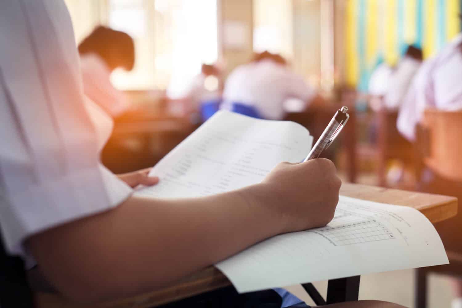 Girl student reading and writing exam with stress.