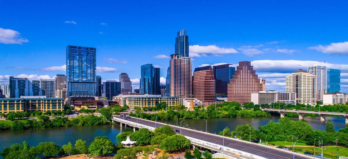 Austin Texas skyline during mid-day sunny summer perfect blue sky with entire city scape office buildings capital cities cityscape auditorium shores Panoramic