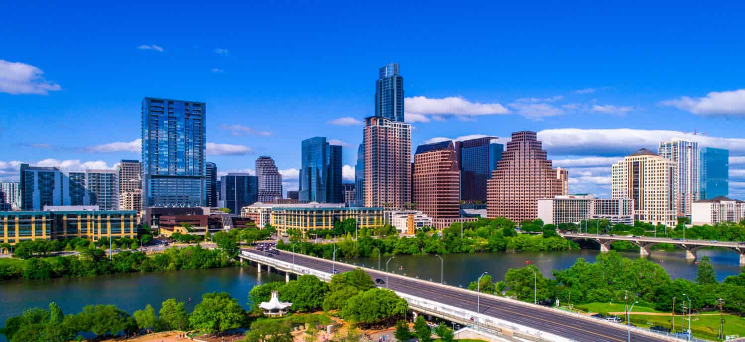 Austin Texas skyline during mid-day sunny summer perfect blue sky with entire city scape office buildings capital cities cityscape auditorium shores Panoramic