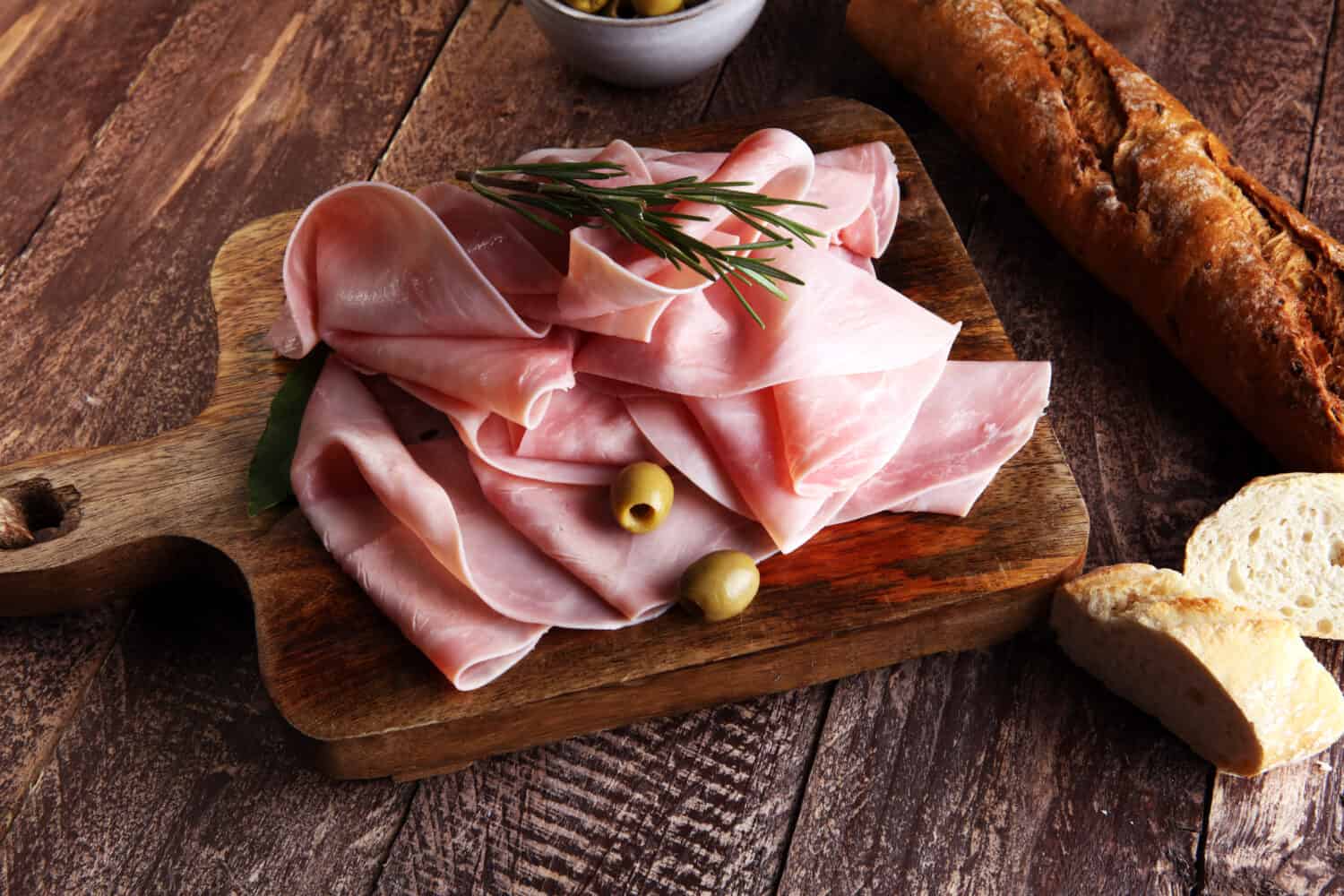 Sliced ham on wooden background. Fresh prosciutto. Pork ham sliced.