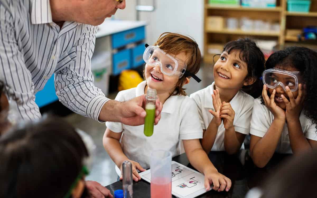 Photo of a group of elementary school students doing a science experiment with their teacher.