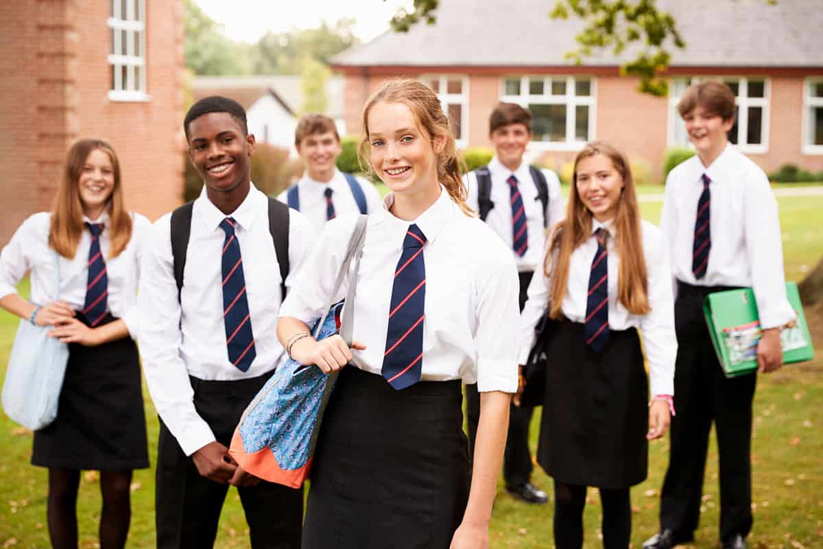 A portrait of students standing outside in their school uniforms.