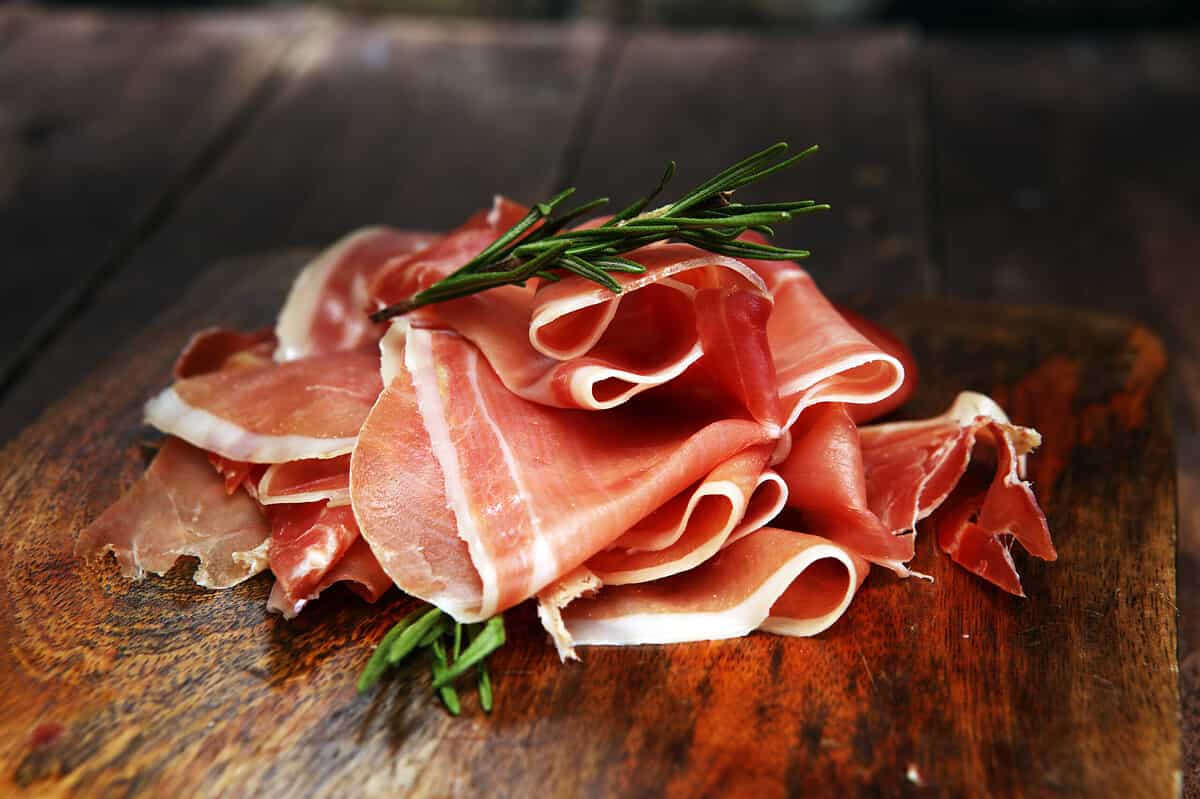 Italian prosciutto crudo or jamon with rosemary. Raw ham.