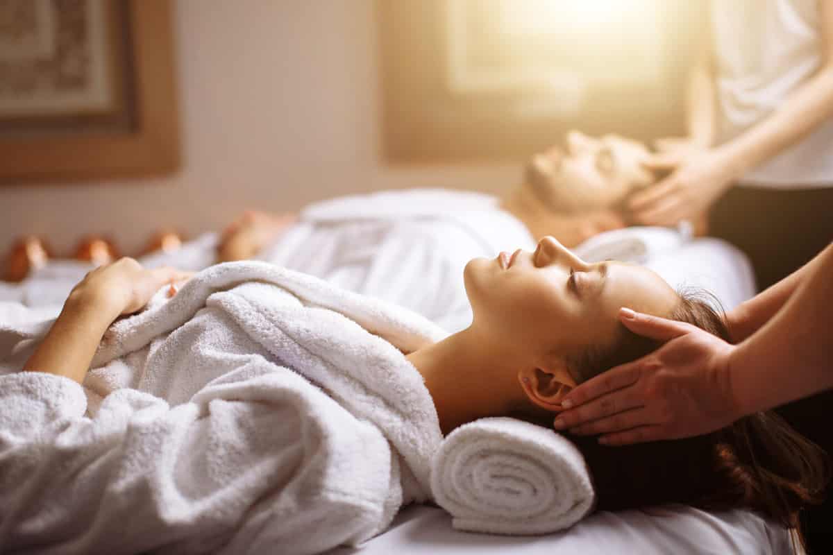 Young couple receiving head massage at beauty spa