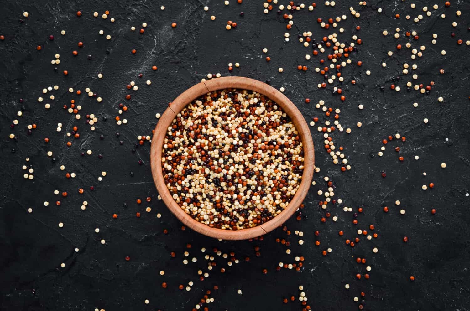 Set of quinoa Red, white and brown quinoa. On a black background. Top view. Free copy space.