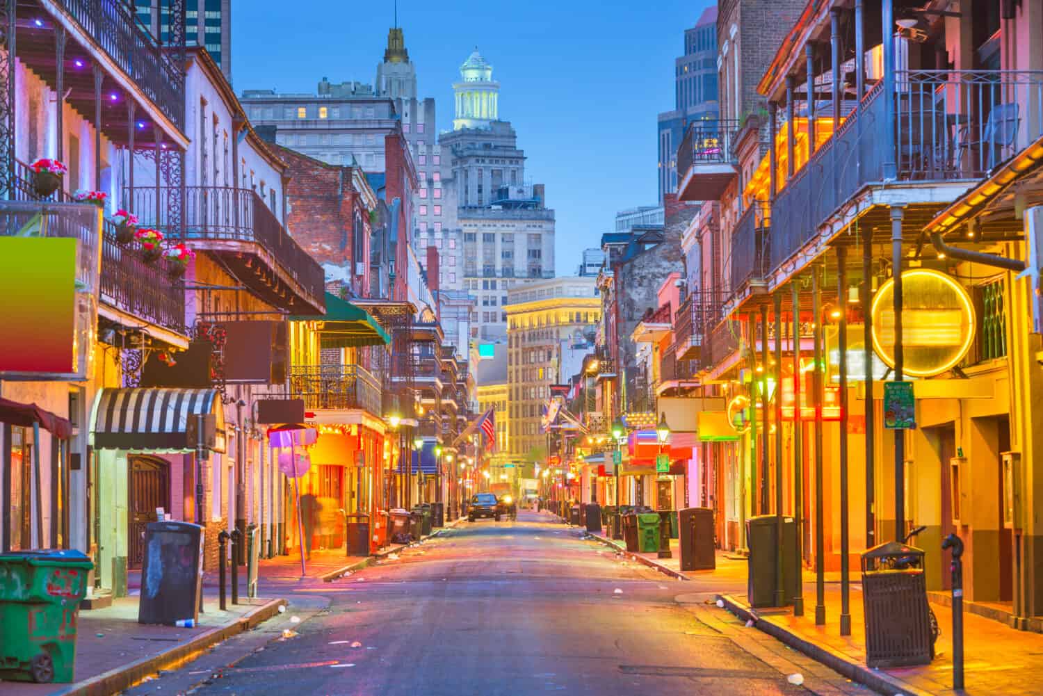 Bourbon St, New Orleans, Louisiana, USA cityscape of bars and restaurants at twilight.