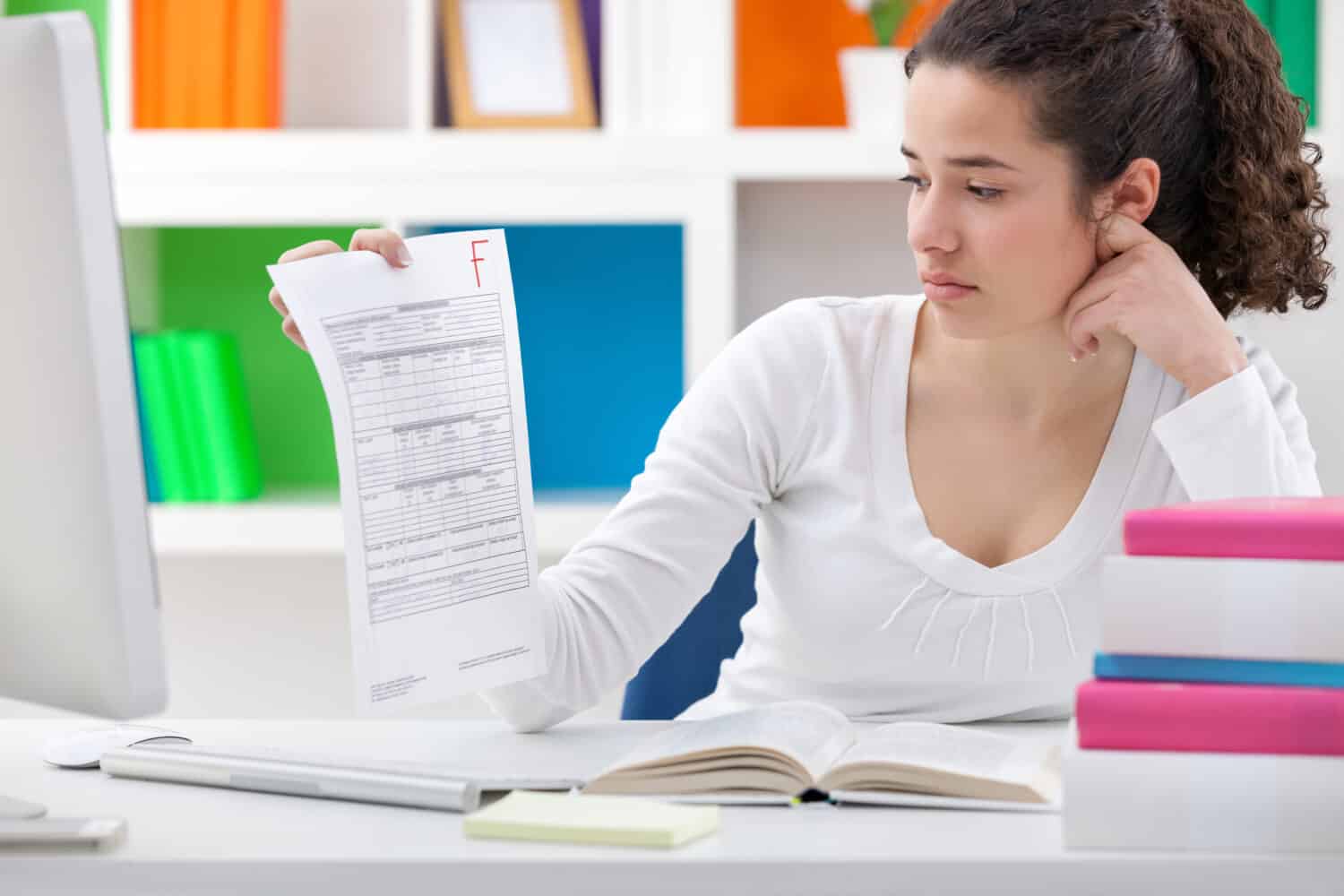 student girl holding a test paper with a failing grade