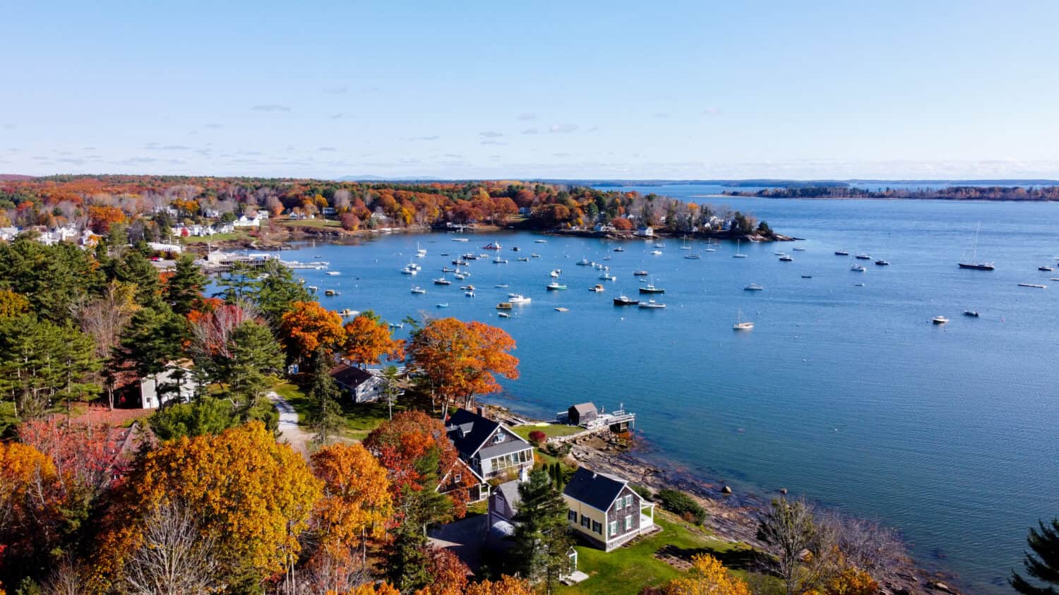 Aerial view of maine coastal harbor - drone picture of lobster boats with the ocean inside a marina sunset - kennebunk maine round pond maine coastal maine