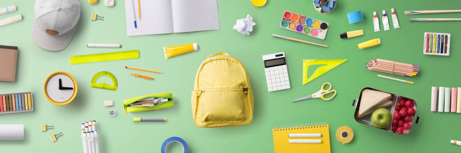 Flat lay top view of face mask and school supplies, back to school and coronavirus concept.