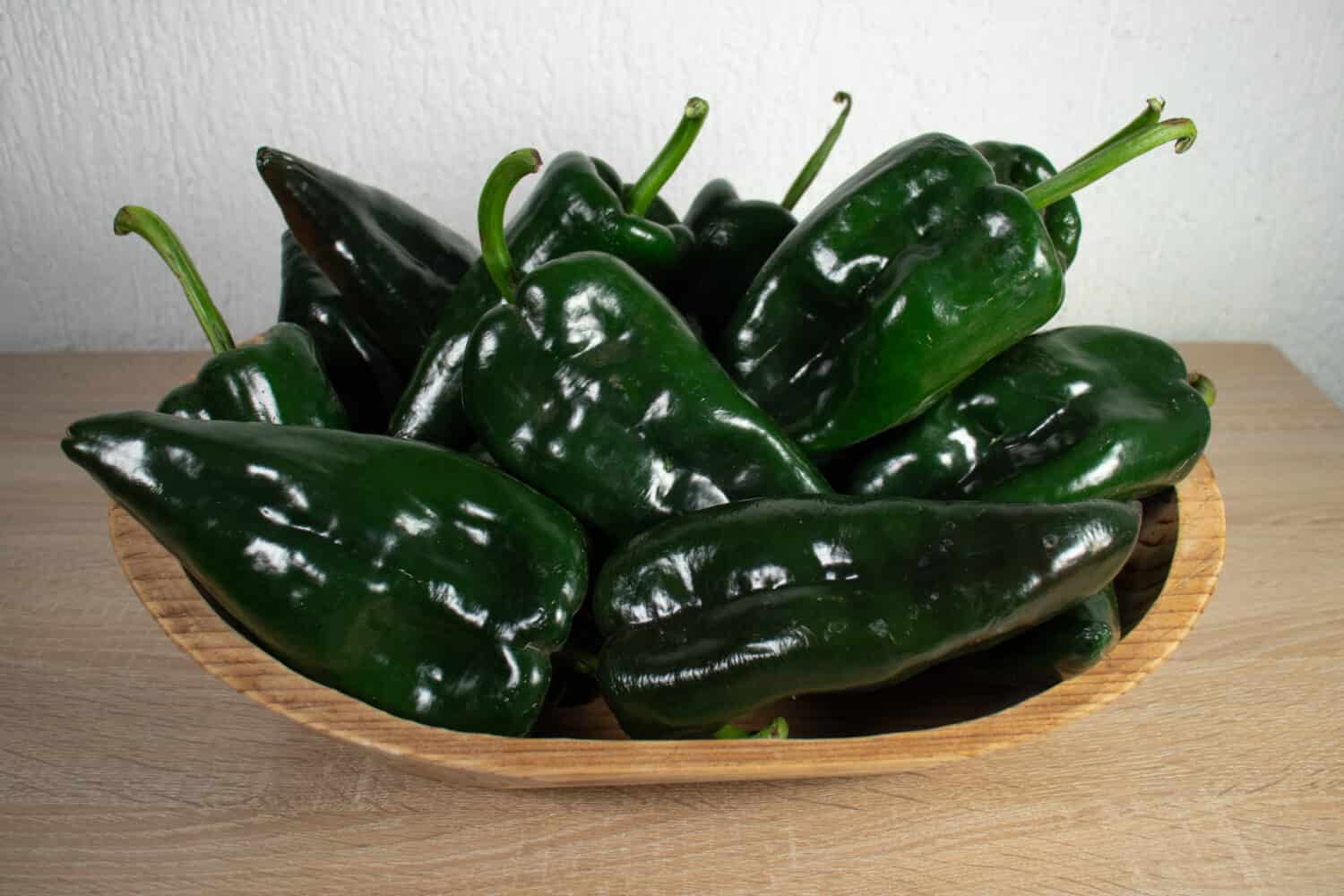 Poblano Pepper's on a wooden basket. Wooden tray with poblano peppers. Chile Poblano.