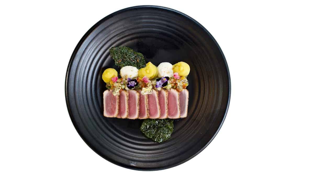Top view of Tuna tataki on black plate, Isolated on white background. Japanese food.