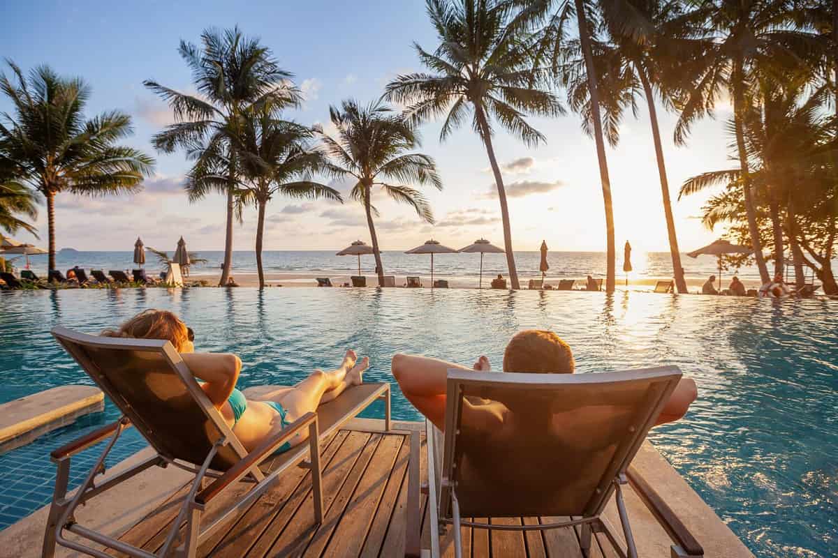 vacation, couple on the beach near swimming pool, luxury travel