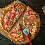 Homemade pizza on peel with ingredients