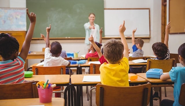 Pupils raising their hands during class at the elementary school