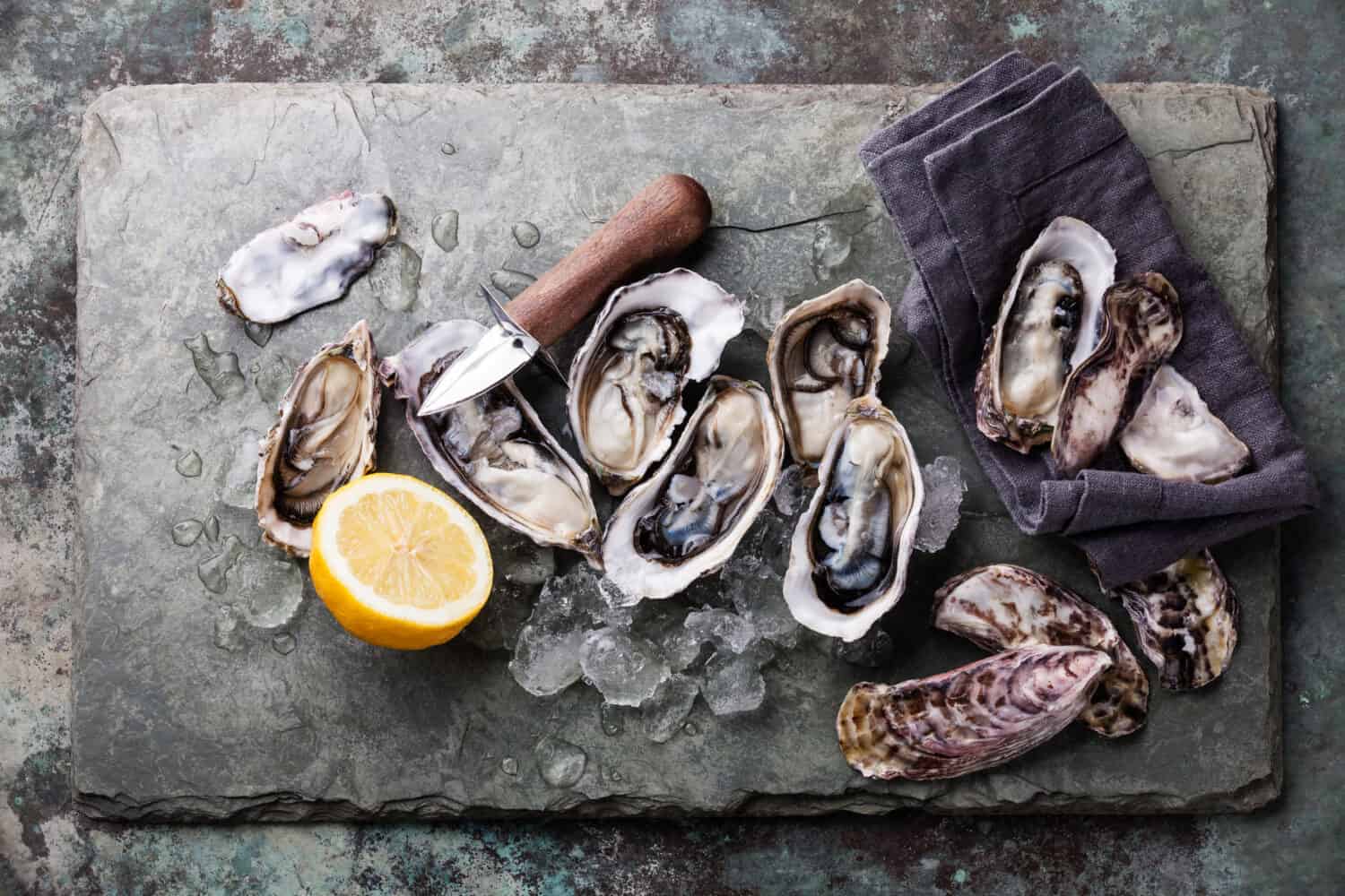 Oysters on stone plate with ice and lemon