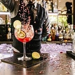 Expert barman is making cocktail at night club.