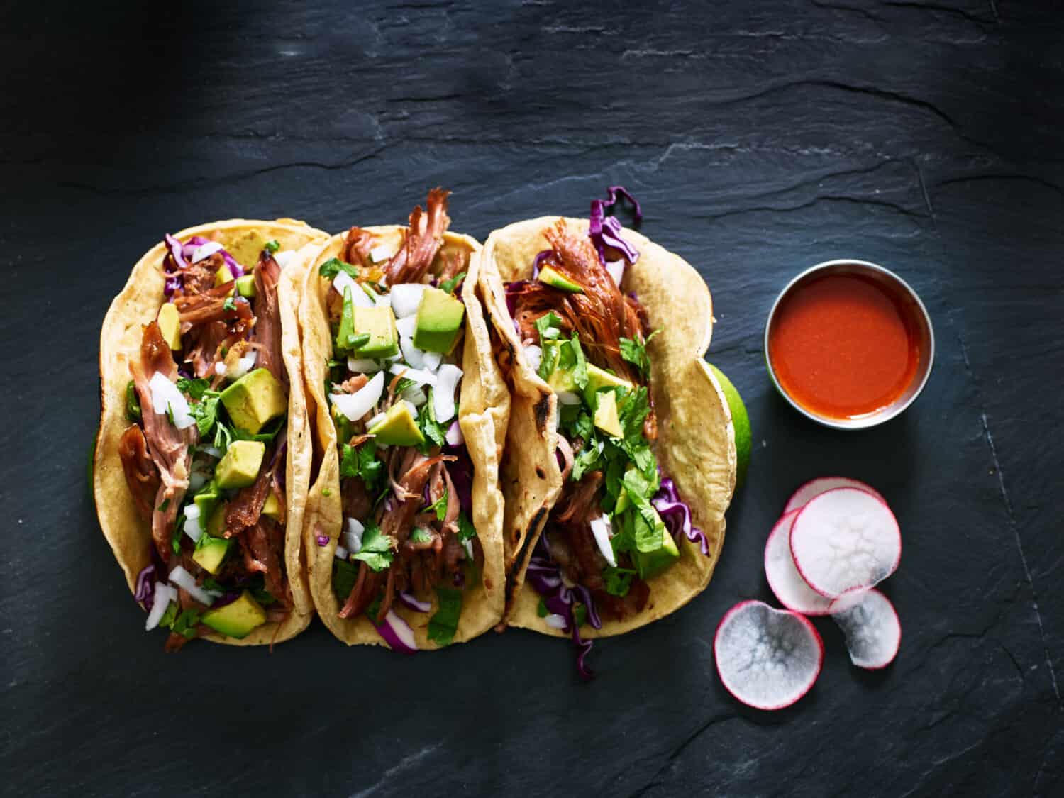 three mexican pork carnitas tacos flat lay composition