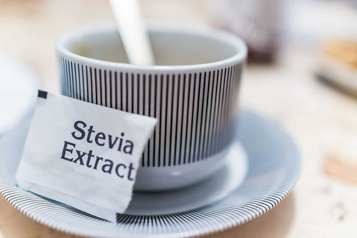 Small coffee cup on plate with stevia extract packet