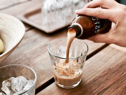 Cold ice latte. pours into a glass. Cold brew.
