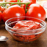 tomato paste in a glass bowl and spoon