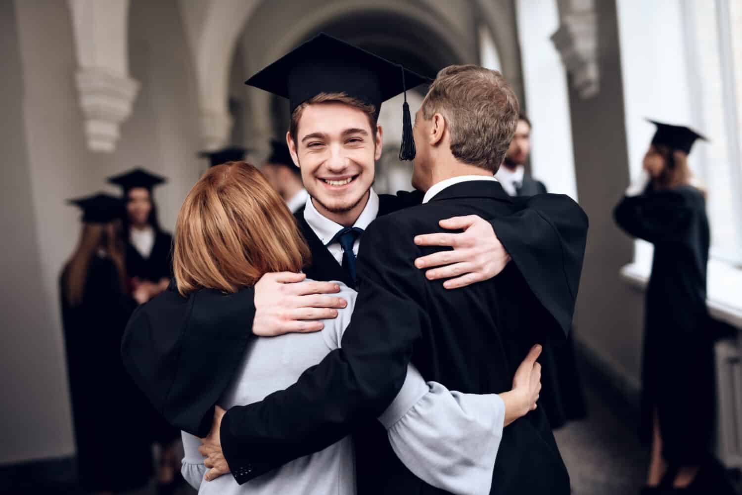 Parents congratulate the student, who finish their studies at the university. He graduates. They are very happy about this.