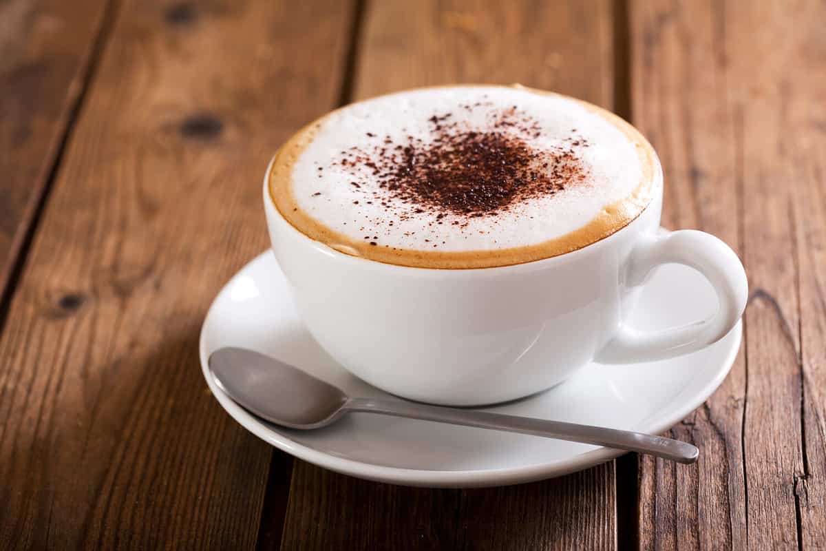 Cup of cappuccino coffee on wooden table