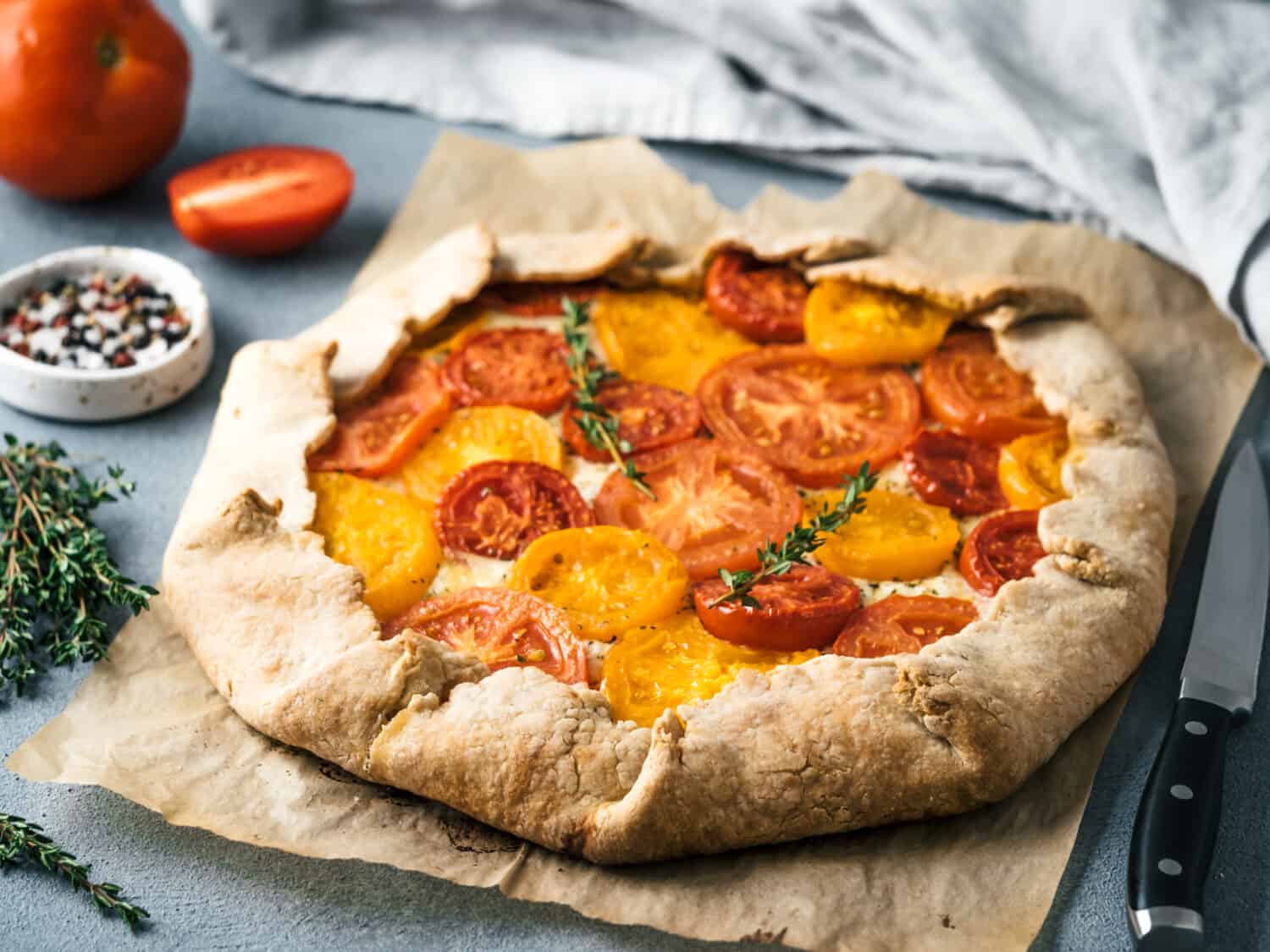 Savory fresh homemade tomato tart or galette.Ideas and recipes for healthy lunch,appetiezer- whole wheat or rye-wheat pie with tomatoes,parmesan cheese,mozzarella.Harvest tomatoes.