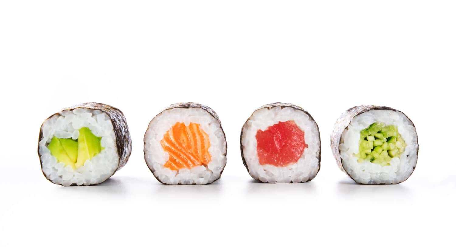 Four maki rolls in a row with salmon, avocado, tuna and cucumber isolated on white background. Fresh hosomaki pieces with rice and nori. Closeup of delicious japanese food with sushi roll.