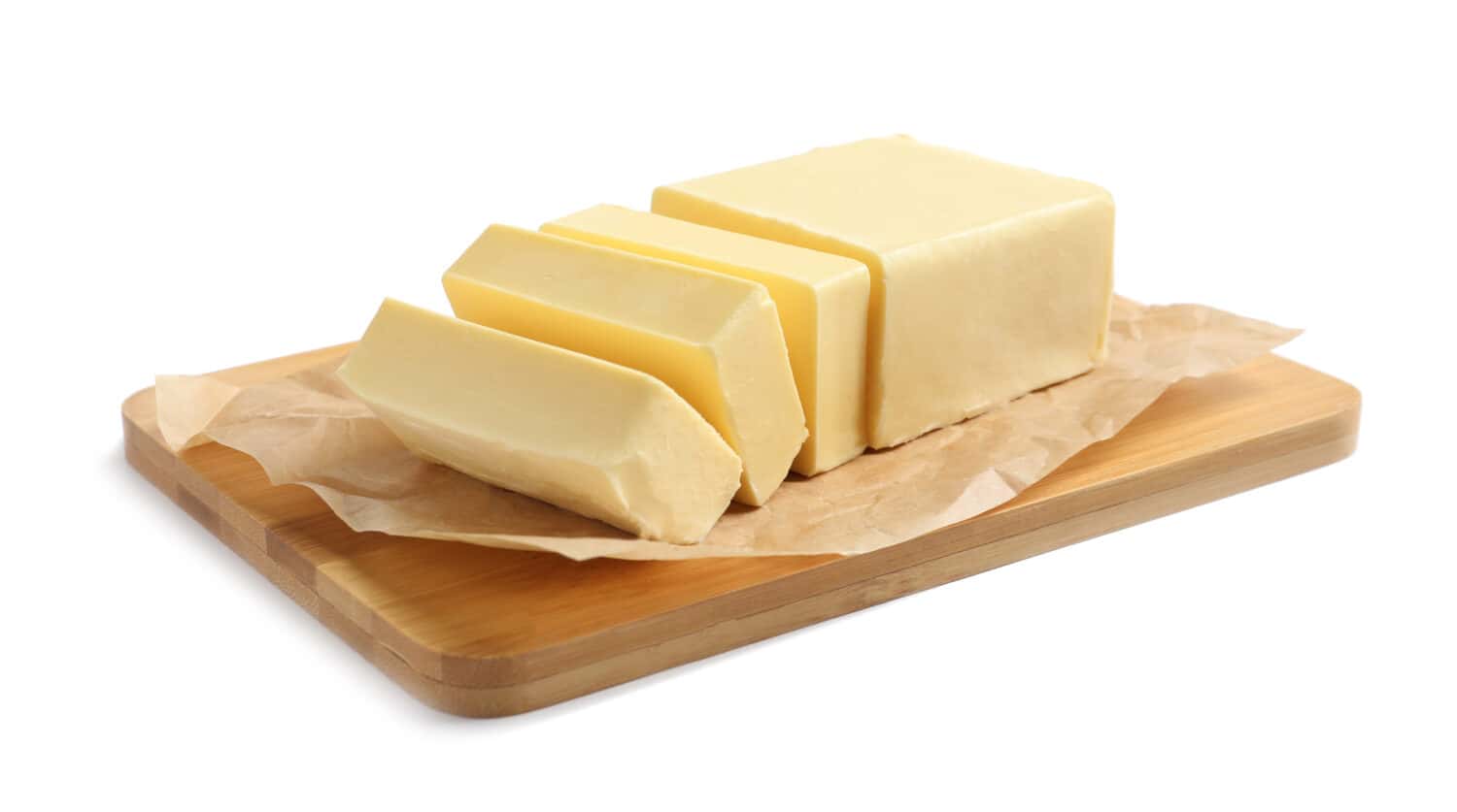 Wooden board with cut block of butter on white background