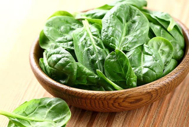 Young spinach in a wooden plate