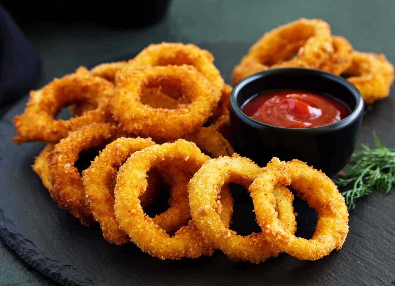 Homemade crunchy fried onion rings with tomato sauce 