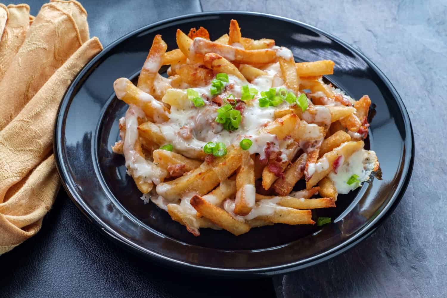 Crispy French fried potatoes loaded with bacon creamy ranch dressing and mozzarella cheese