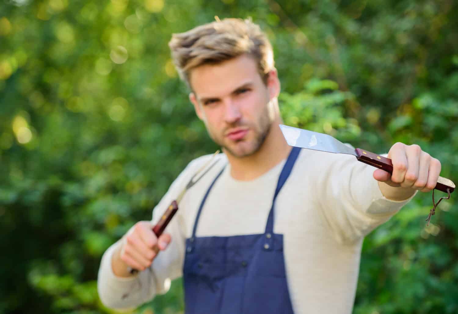 Need some help. Culinary concept. Chef cooking bbq food. picnic cooking utensils. Outdoor party weekend. Family weekend outing. Summer picnic. Tools for roasting meat outdoors. man barbecue grill.