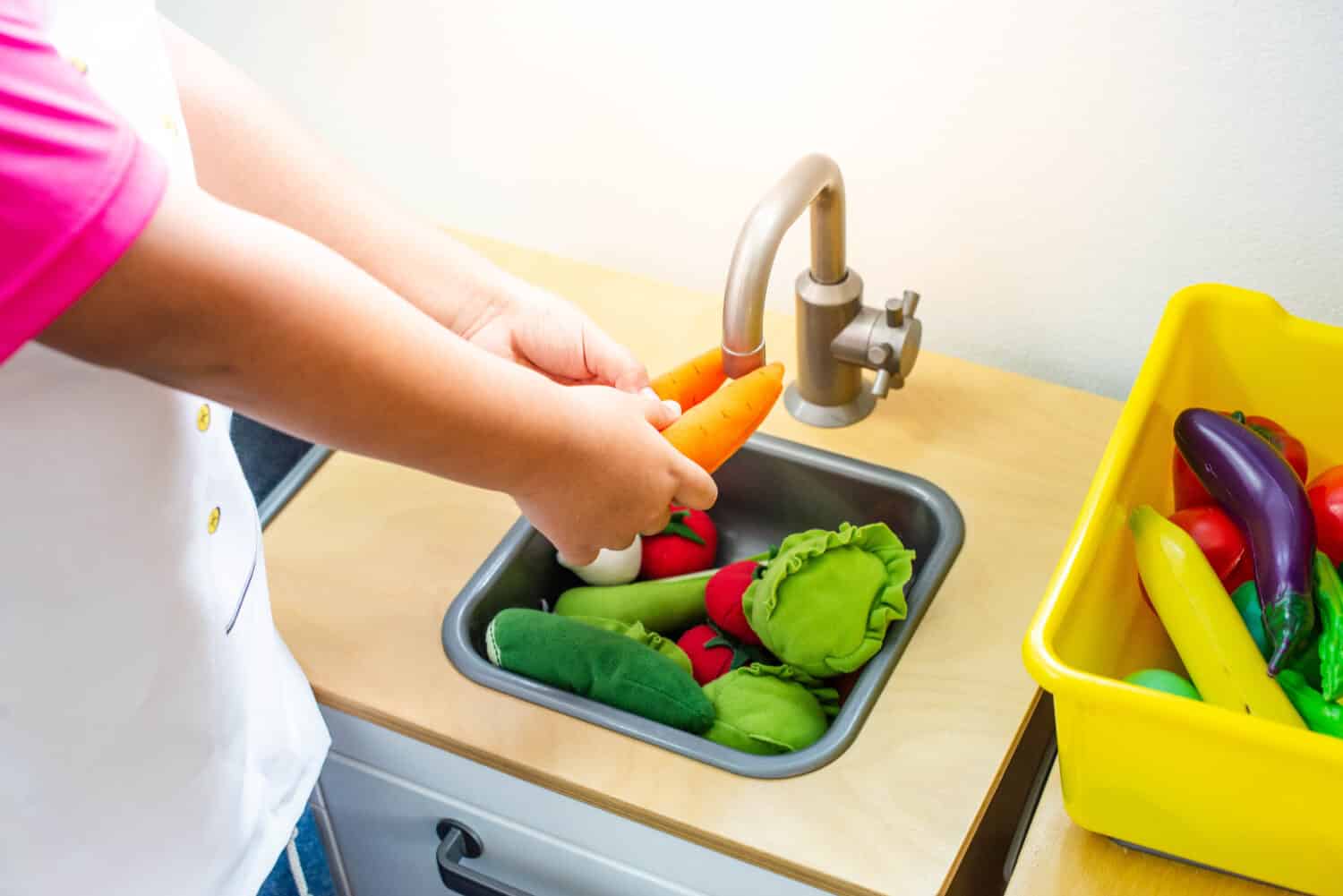 Little boy chef cooking in toy kitchen, Kids play and cook at school.