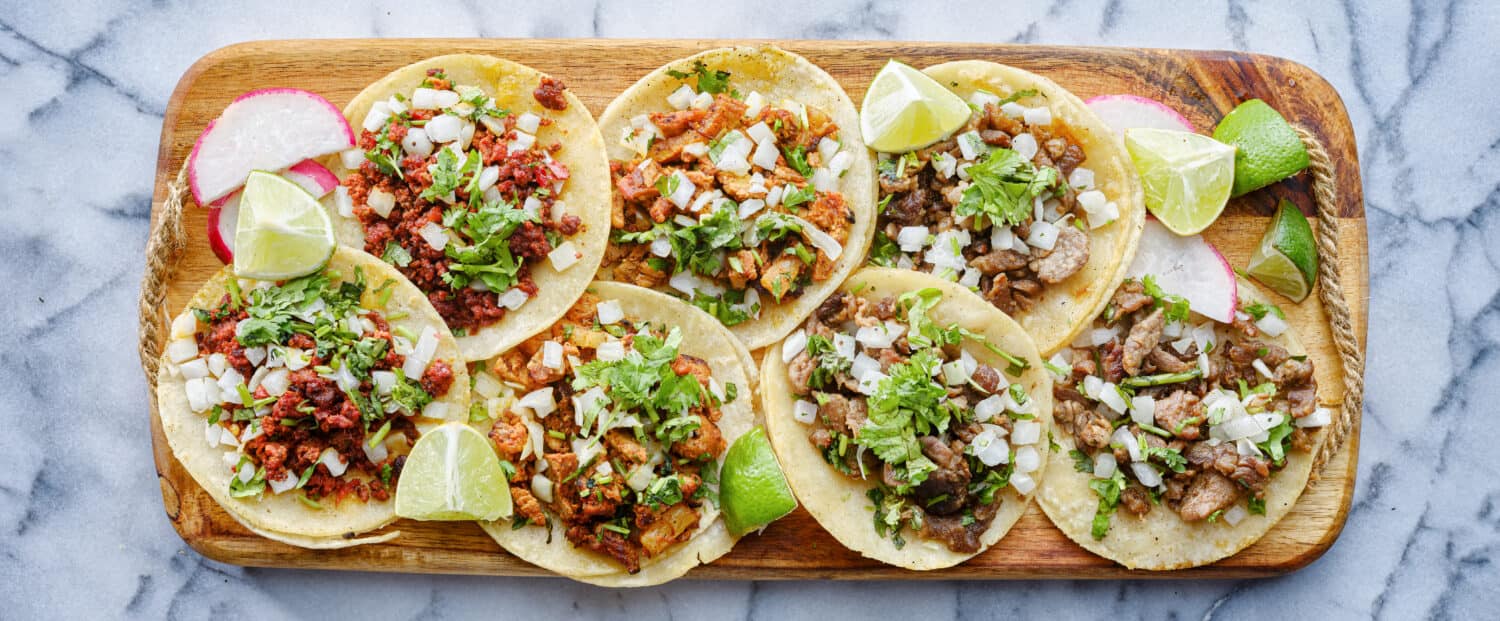 wooden tray full of mexican street tacos