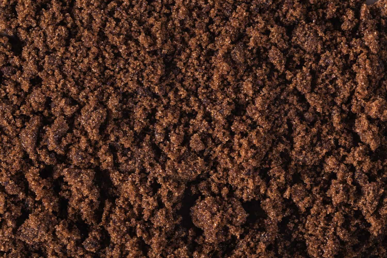 Dark muscovado sugar texture, background.