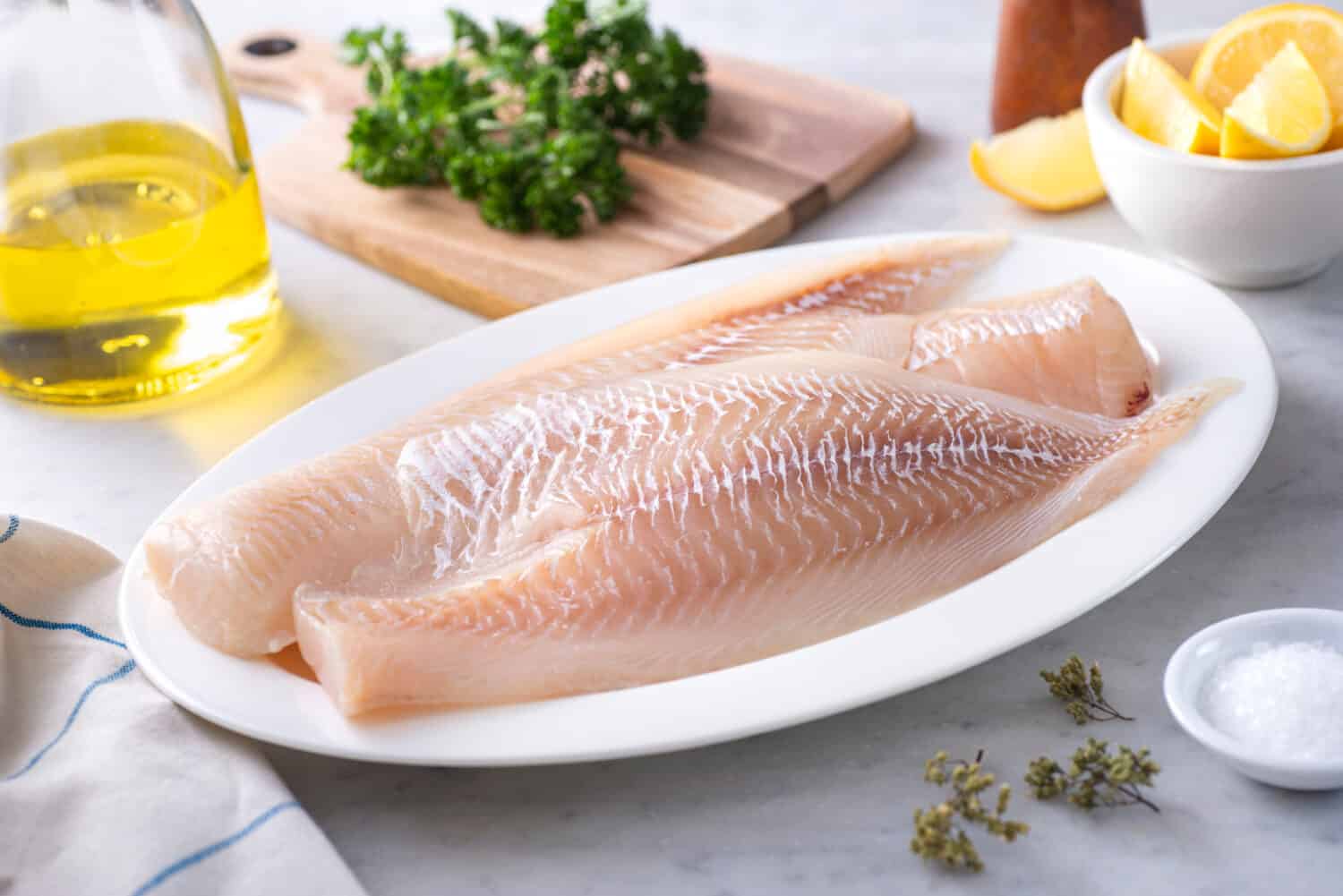 Fresh Icelandic Haddock Fillets on a plate with lemon and parsley.