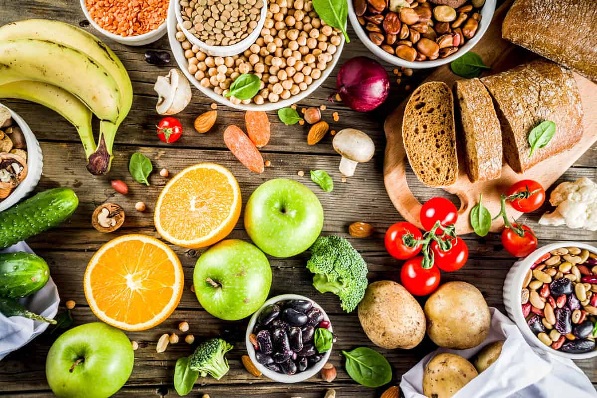 Healthy food. Selection of good carbohydrate sources, high fiber rich food. Low glycemic index diet. Fresh vegetables, fruits, cereals, legumes, nuts, greens. Wooden background copy space