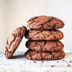 Fresh homemade chocolate chip cookies on a wooden background.