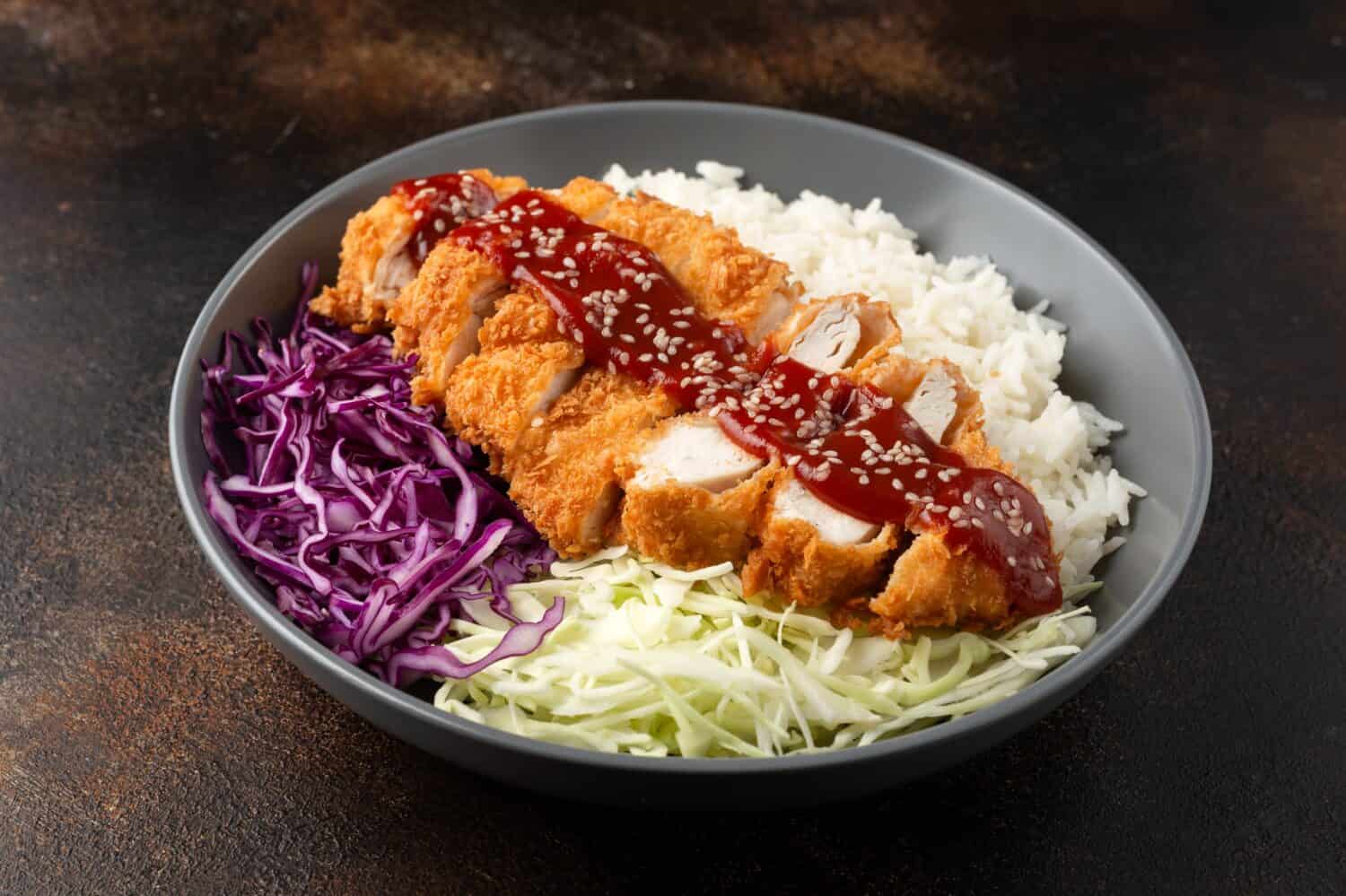 Crispy Katsu chicken with sauce, rice and cabbage.