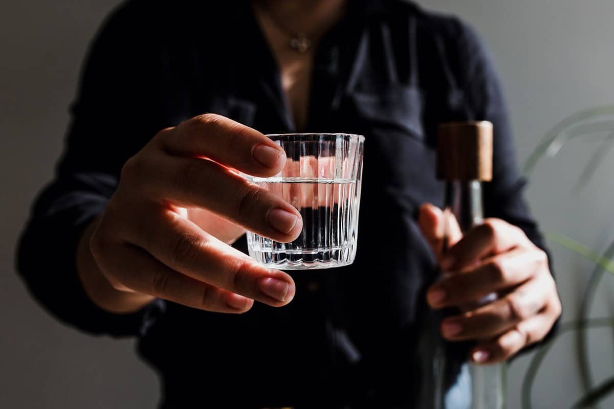 bartender hand serving mexican mezcal shot drink in a traditional glass in Mexico city Latin America