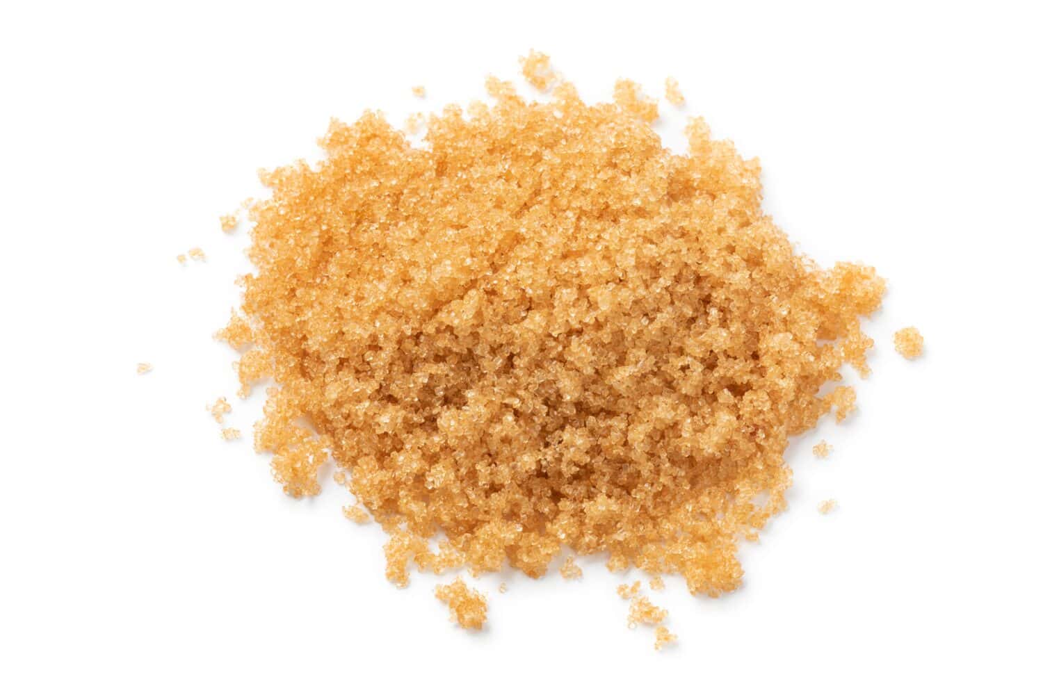 Heap of soft light brown sugar close up isolated on white background