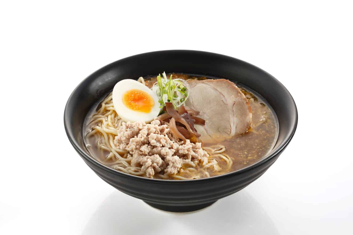 Shoyu- Tonkotsu Ramen (Ramen noodles in pork and shoyu broth soup) in a bowl on white background.