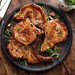 Grilled or pan fried pork chops on the bone with garlic and rosemary