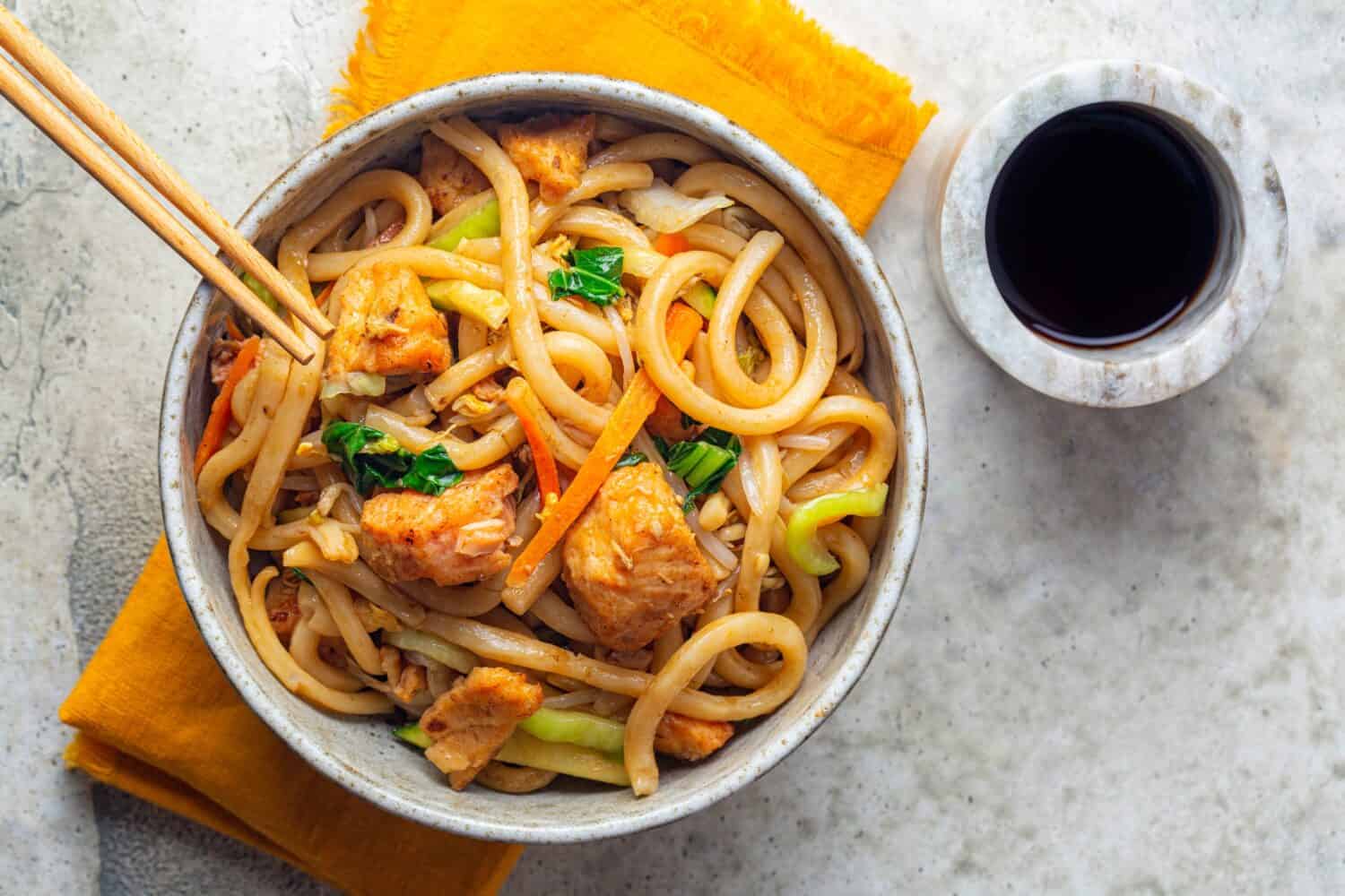 Stir Fried Yaki Udon Noodles with Salmon Fish, Vegetables and Soy-based Sauce. Directly above.