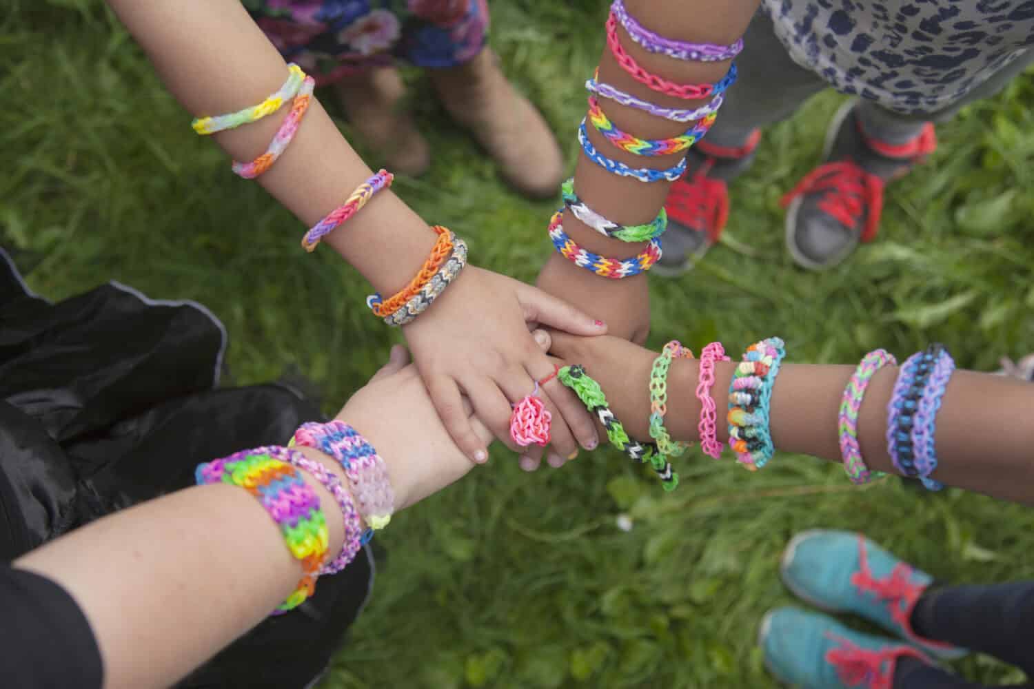 Girls with loom bracelets putting their hands together