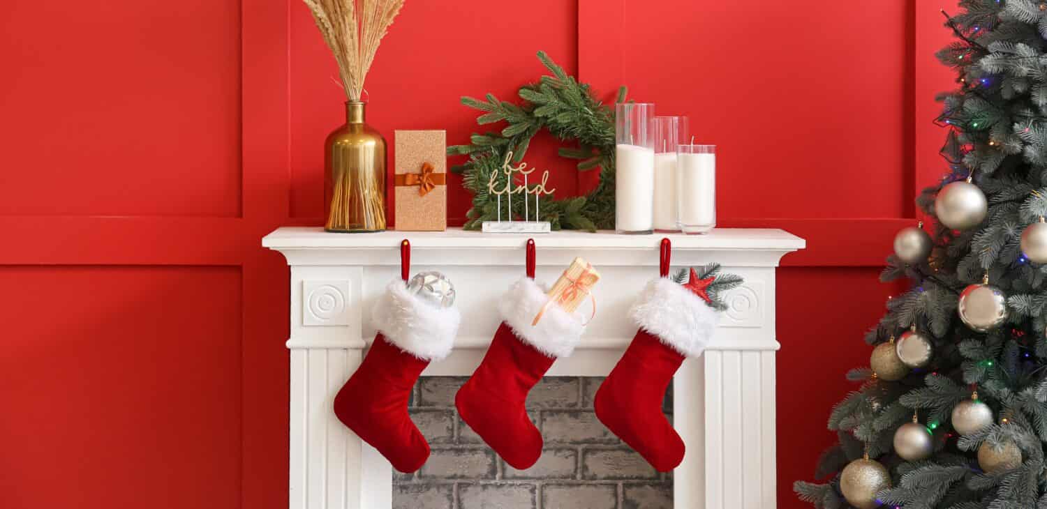 Christmas socks with gifts on fireplace in living room