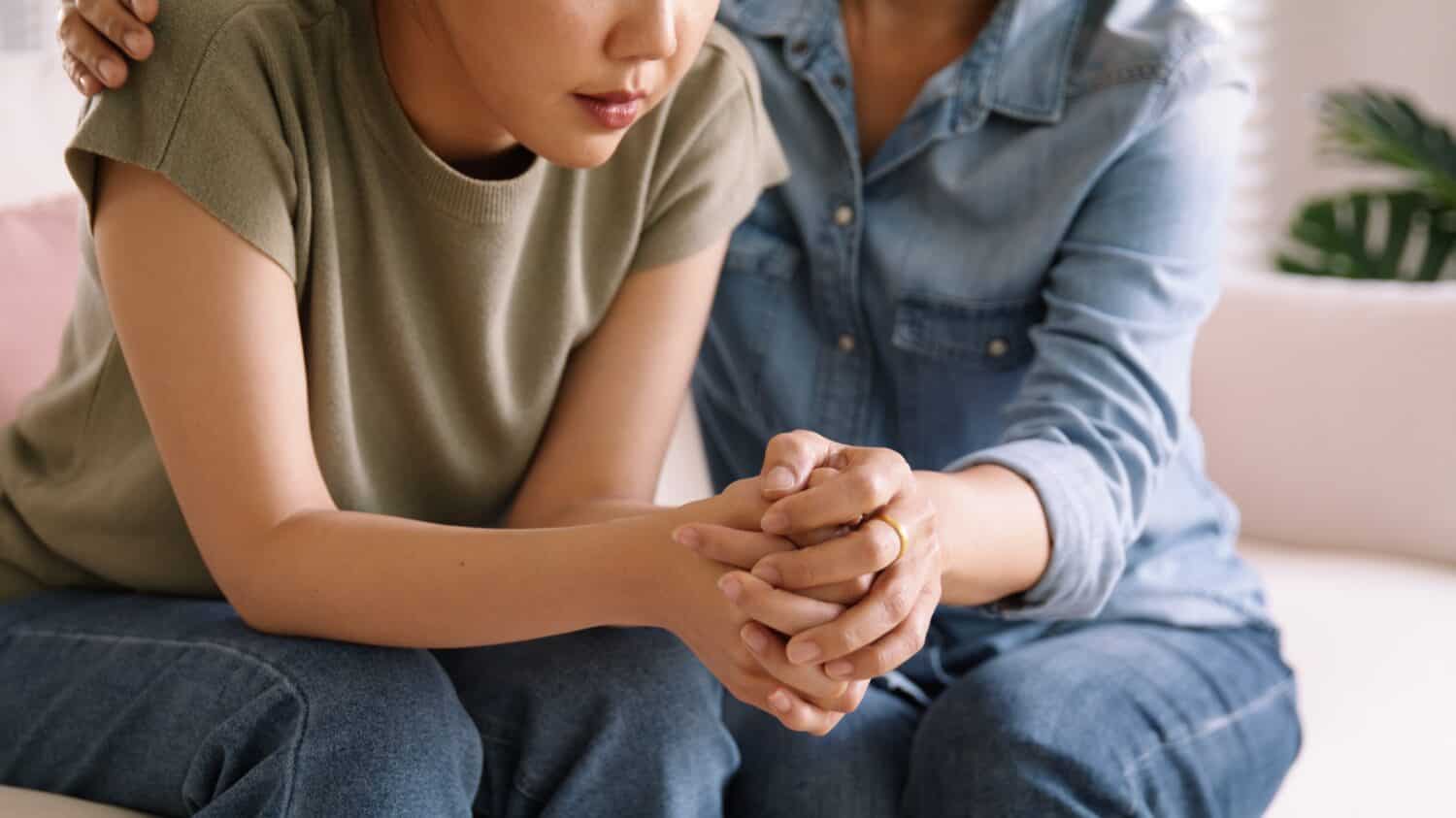 Middle aged asia people old mom holding hands trust comfort help young woman talk crying stress relief at home. Mum as friend love care hold hand adult child feel pain sad worry of life crisis issues.