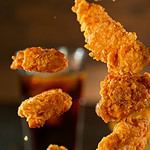 Freeze Motion Shot of Flying Fresh Fried Chicken Wings or Strips, Close-up